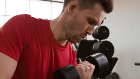 man exercising with a dumbbell in the gym