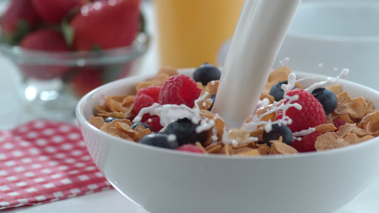 la leche se vierte en un cuenco de cereales y bayas