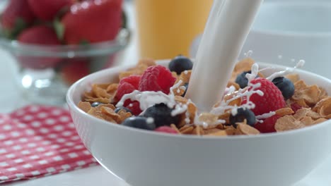 la leche se vierte en un cuenco de cereales y bayas