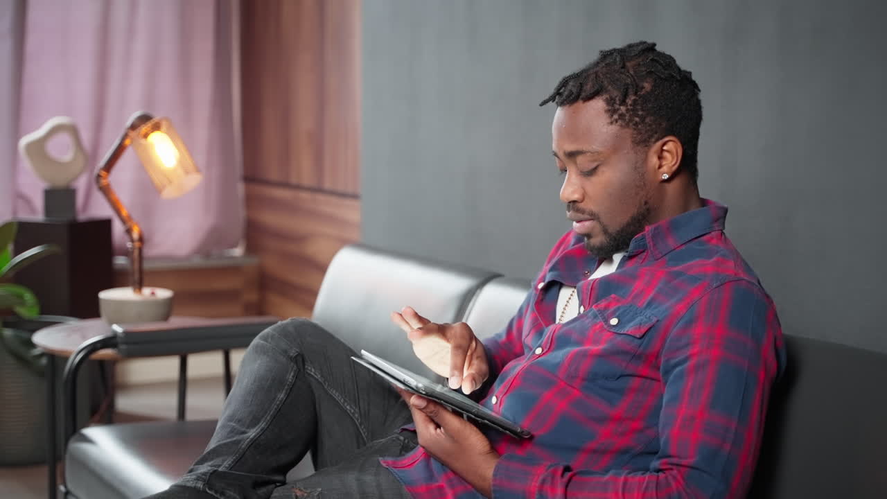 Man using tablet on couch in living room