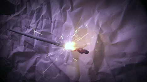 primer plano de la luz de fuegos artificiales bengala y un fondo de papel rayado