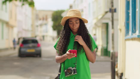 Turista-Femenina-Con-Cámara-De-Vacaciones-En-Oxford,-Reino-Unido,-Explorando-La-Ciudad-Caminando-Por-Holywell-Street-Usando-Un-Teléfono-Móvil-Para-Obtener-Direcciones-E-Información-1