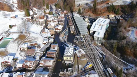 flying over snowy village towards train station | lauterbrunnen switzerland, swiss valley in alps drone, europe, 4k