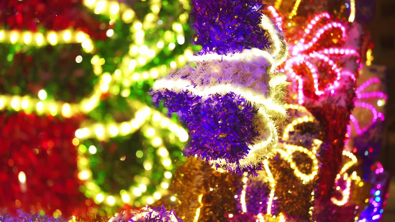 colorida y brillante decoración navideña. decoración reluciente de neón brillante en la calle de cerca. feliz año nuevo. celebración de las vacaciones de invierno en la ciudad nocturna. imágenes en 4k