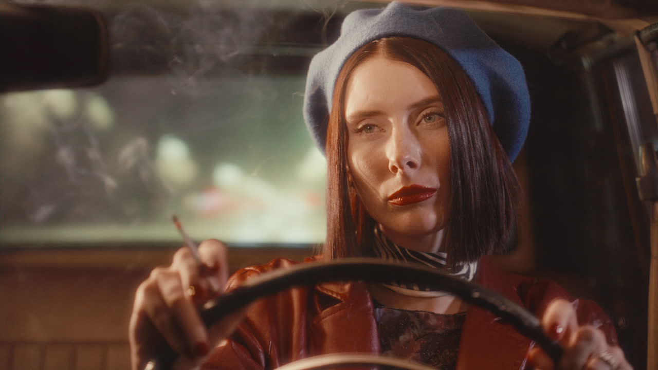 Beautiful Woman with Red Lipstick Smoking While Driving Vintage Car