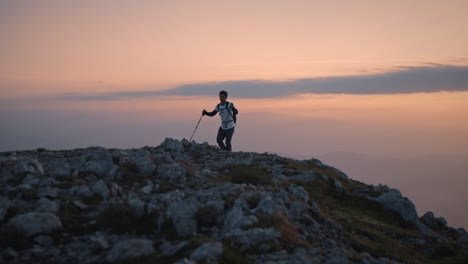 una cámara que sigue a un caminante caminando hasta la cima de la montaña peca temprano en la mañana