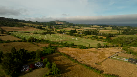 aerial of wide open agricultural land in puerto varas with volcano rising in distance, establishing dolly