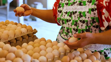 woman choosing eggs at floating market stall