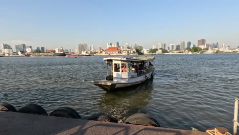 a boat moves towards the city across calm waters.