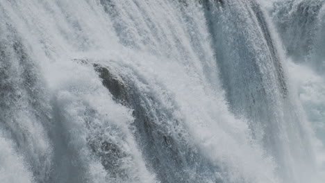 a waterfall with a large amount of water on a clean and wild mountain river