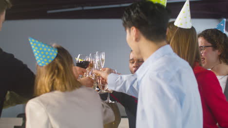 happy multiethnic colleagues toasting with champagne and wine and drinking at the office party 2