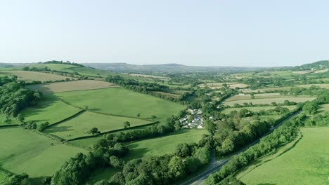 cinematic aerial approach towards a small picturesque village in rural britain