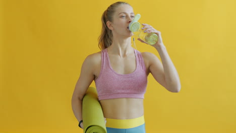 woman drinking water after yoga
