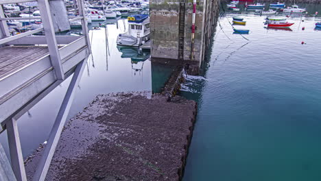 The-tide-going-down-at-a-port-with-many-boats-docked---time-lapse