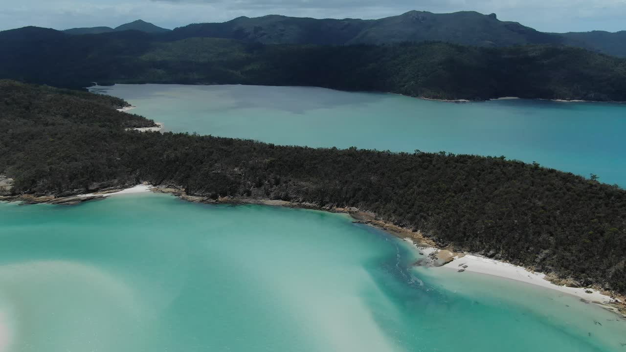 Volando sopra incredibili acque limpide e verdi e spiagge di sabbia bianca nelle Whitsundays, vicino alla Grande Barriera Corallina, con drone.