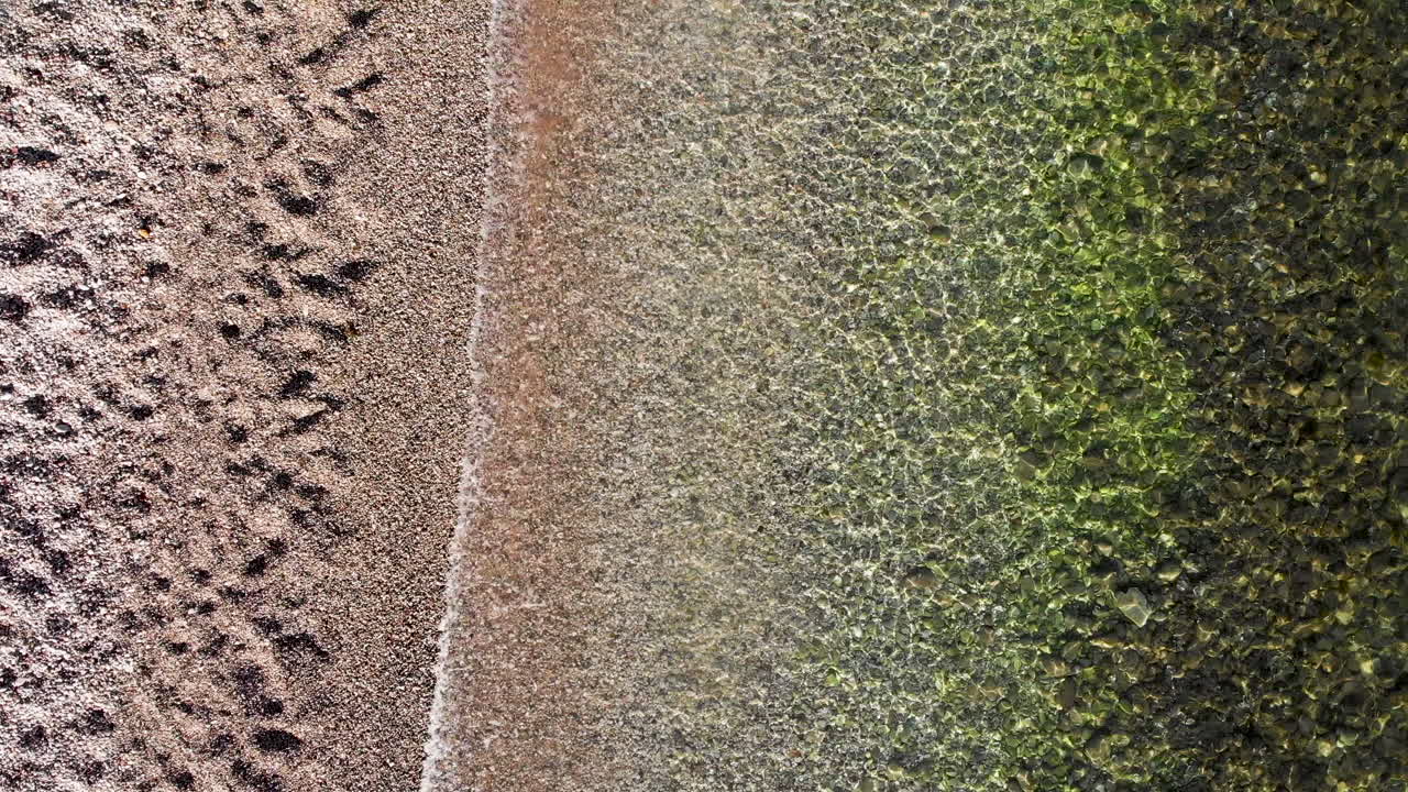 hermosas olas claras y transparentes rodando en la playa en grecia - vista superior