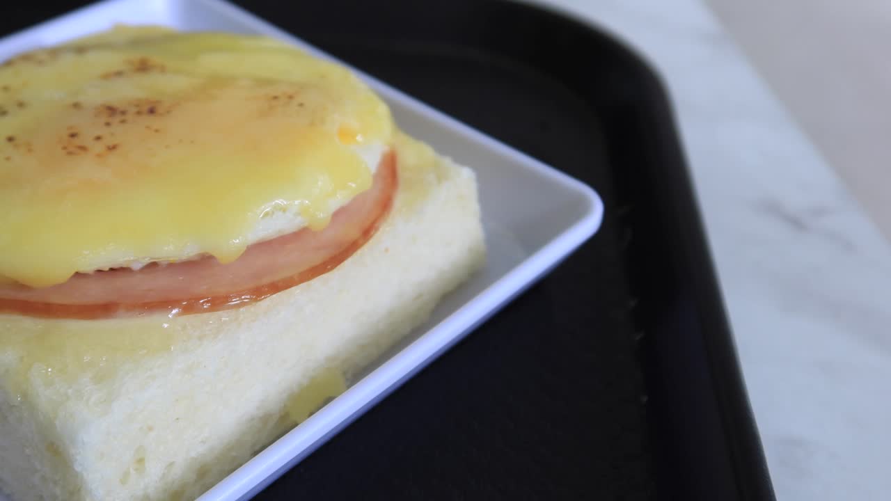 jamón curado, huevo y pan y una taza de té en la mesa