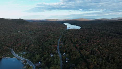 carretera rodeada de exuberantes bosques de otoño - toma aérea de un dron