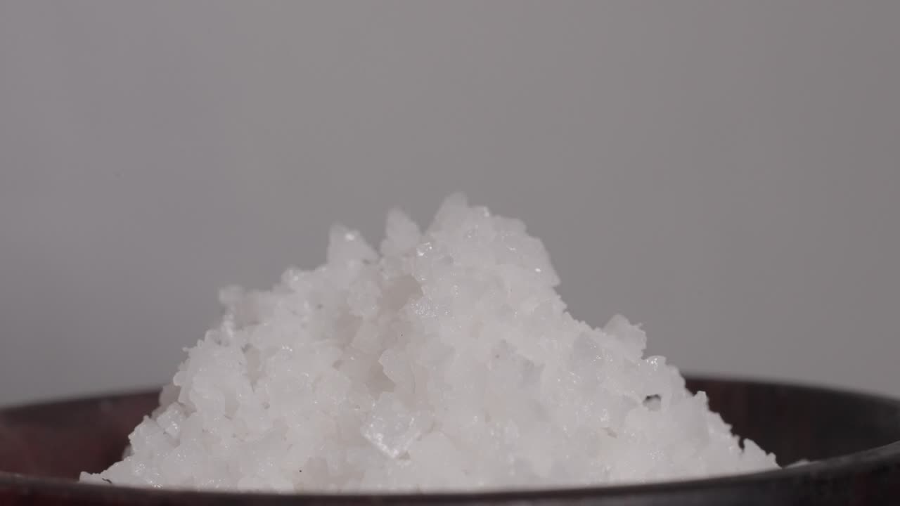 Close-up of coarse salt served in a wooden cup, showcasing natural textures and simplicity