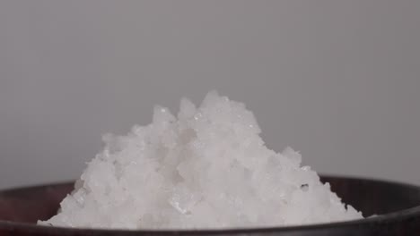 close-up of coarse salt served in a wooden cup, showcasing natural textures and simplicity