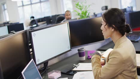 Asian-businesswoman-using-computer-with-copy-space-in-office,-slow-motion