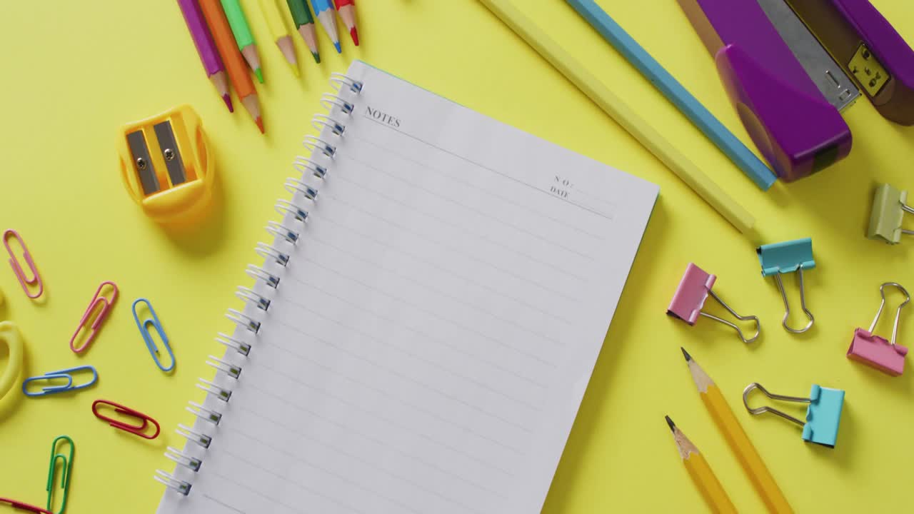 video de suministros escolares y cuadernos, clips de papel, bolígrafos sobre fondo amarillo