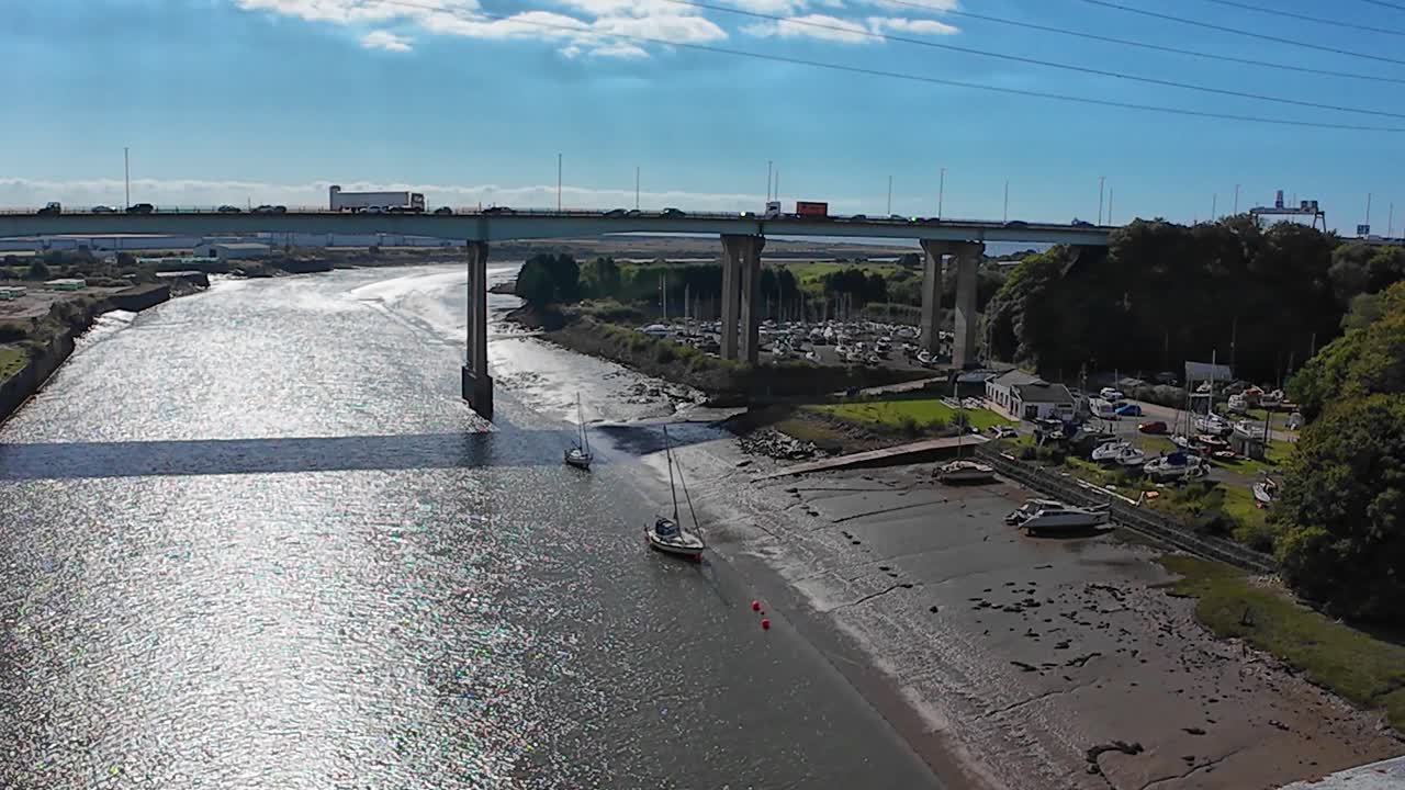 Pan Across Mouth of River Neath at Low Tide with Overpass Bridge with Busy Traffic Passing with Trucks and Cars
