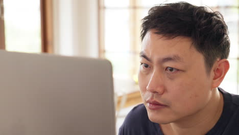 close up of asian man looking on computer screen