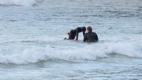 two surfers practicing skills in ocean waves