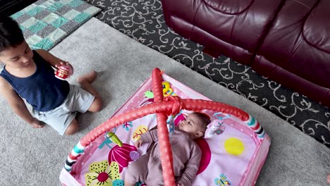siblings bonding near a colorful playmat showcasing interaction and cheerful environment
