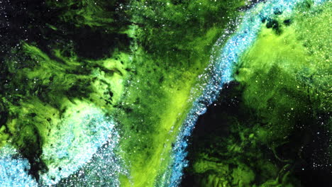 glittery green and blue liquids swirl and mix in vibrant macro fluid art motion