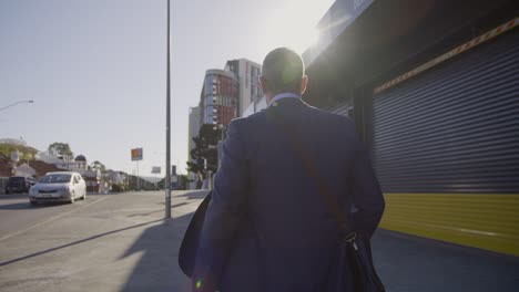 man in a suit walking in the day through the cbd in slow motion