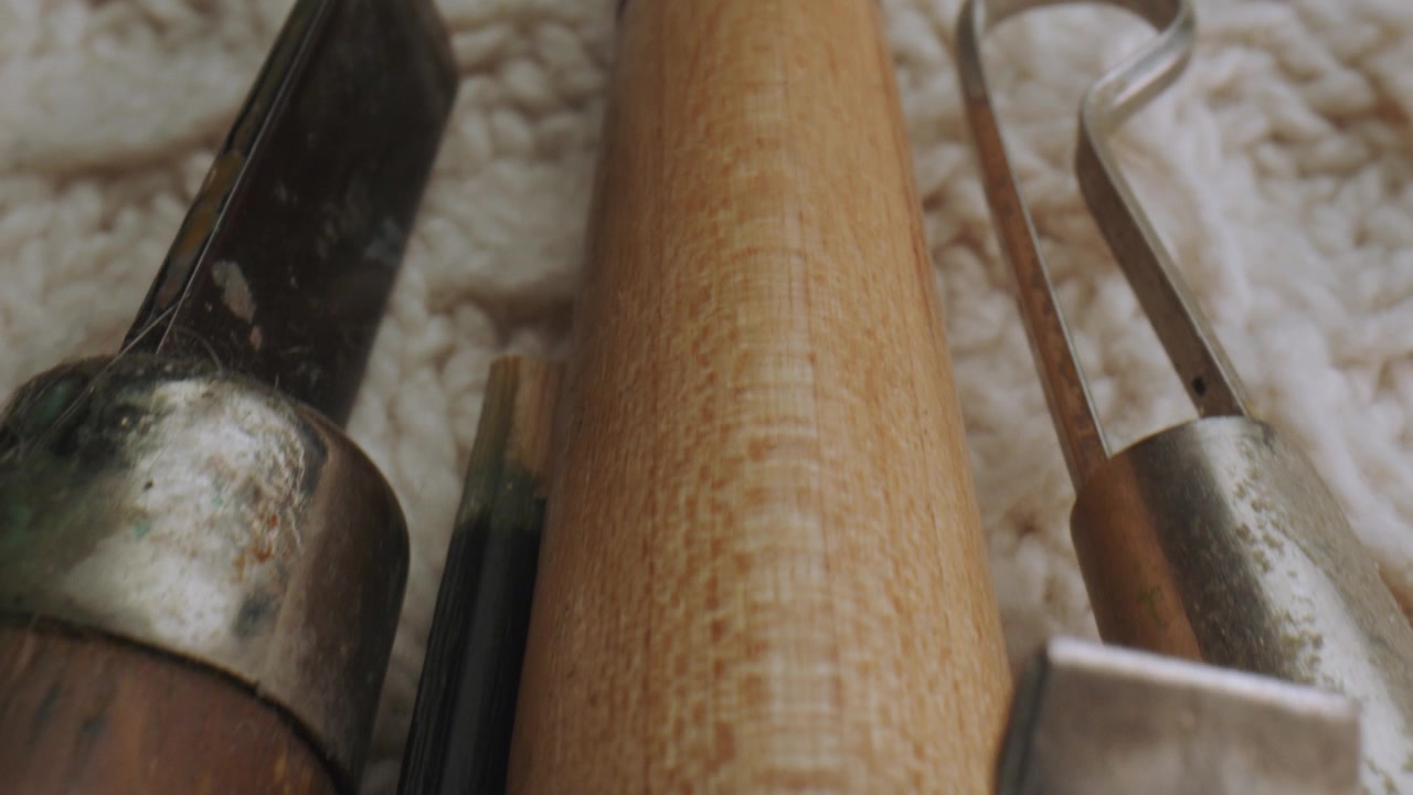 Close-up of various sandpaper and vintage wooden handle objects arranged on white wool