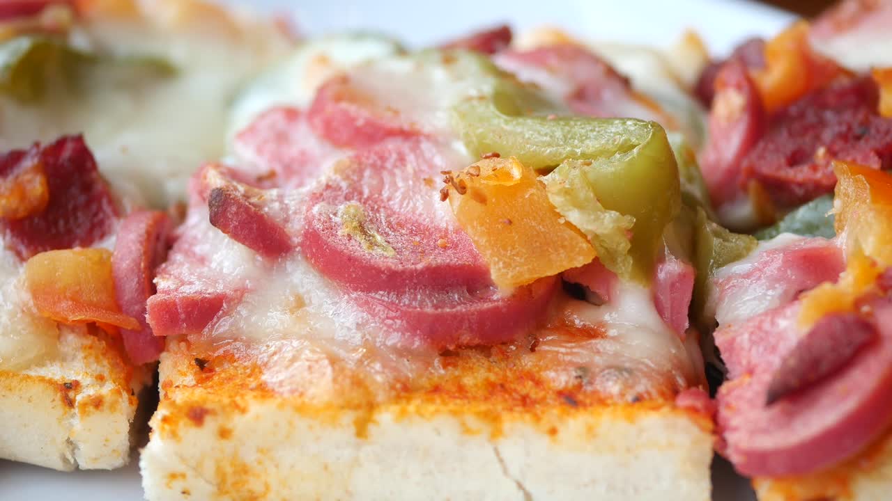 Close-up of a Pizza Slice with Sausage and Peppers