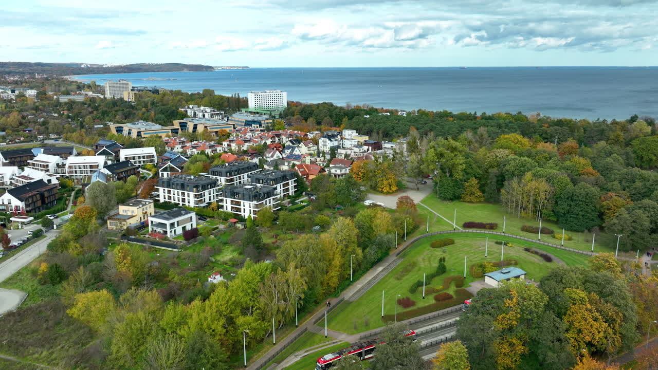 Aerial panorama of Gdańsk Orłowo showing modern apartments, sea horizon, and autumn trees