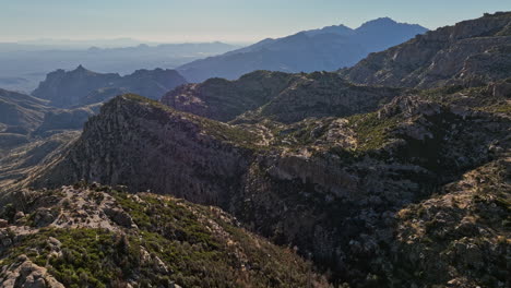 Mt-Lemmon-Arizona-Aerial-v5-drone-flyover-Windy-Point-Vista,-panning-reveals-vast-wilderness,-showcasing-wind-whipped-rock-formation-and-Tucson-mountain-landscape---Shot-with-Mavic-3-Cine---March-2022