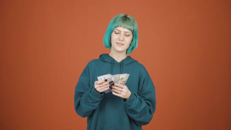 Young-woman-counting-money-looking-at-camera.