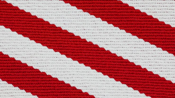 Strukturierter Strickstoff mit roten und weißen horizontalen Mustern