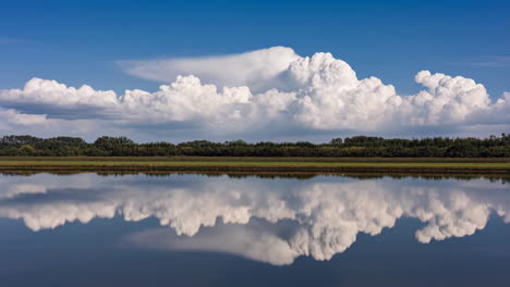 dramatic clouds reflected in calm water
