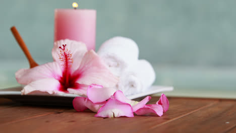 toallas, velas y flores rosas junto a la piscina.