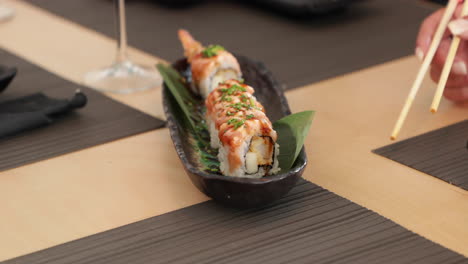 Eating-Salmon-Sushi-Rolls-With-Shrimp-Tempura-Using-Chopsticks---close-up