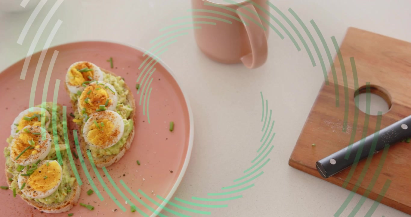 Knife starting slicing bread on board, crumbs scattering, making avocado egg toast and mug on plate