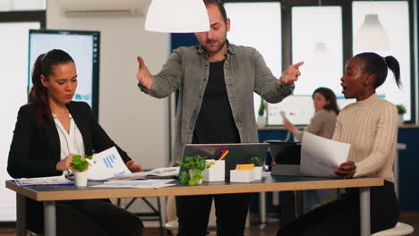 hombre de negocios enojado gritando a varios colegas durante una reunión de oficina