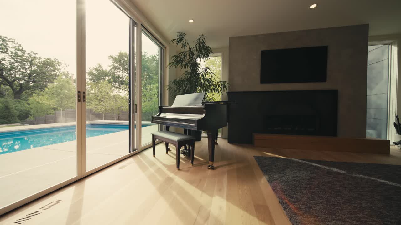 um grande piano na sala de estar de uma casa de luxo ao lado de grandes portas de vidro deslizantes olhando para uma piscina