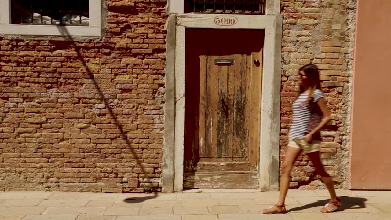 Female model walking and exploring a Venetian street, Venice, Italy