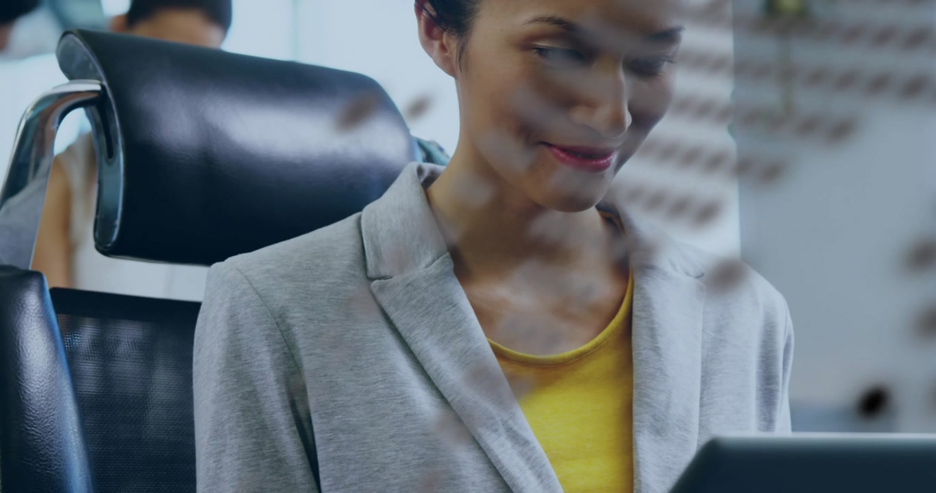 Business office digital dot overlay drifting aside revealing woman tapping tablet to review files