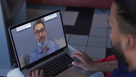 hombre de negocios afroamericano usando una computadora portátil haciendo una videollamada con un colega