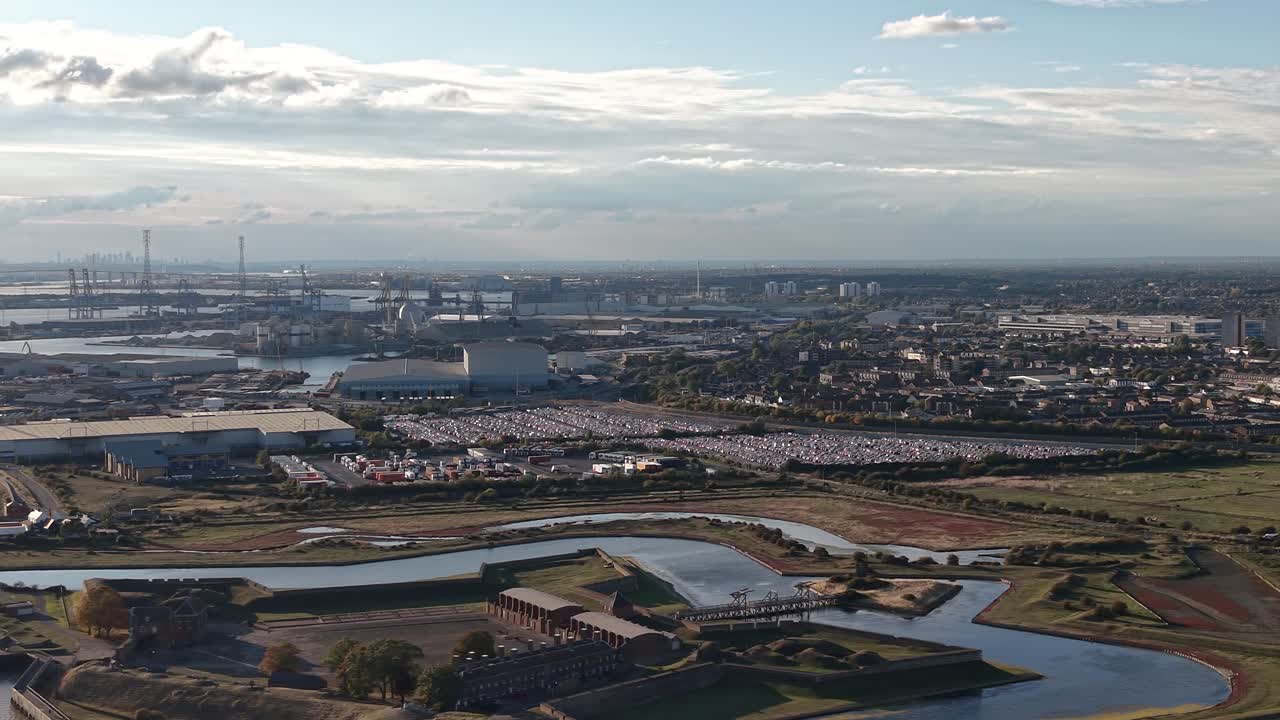 Aerial view above Port of Tilbury fortress and industrial shipping docks skyline at sunrise