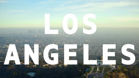 aerial drone shot of city buildings and skyline in america overlaid with animated graphic spelling out los angeles