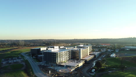 High-speed-drone-aerial-maneuver-working-its-way-above-newly-developed-shared-working-facilities-and-nearby-highway